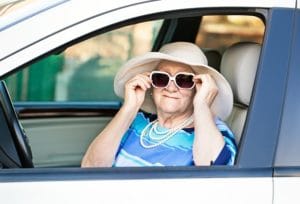 old woman in sunglasses sitting in the car