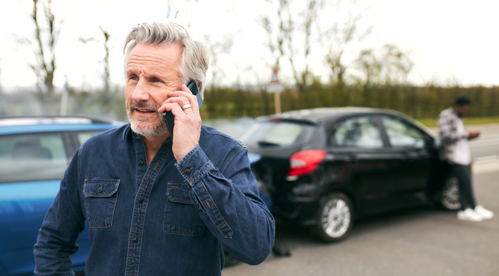 A driver making a phone call after a car accident