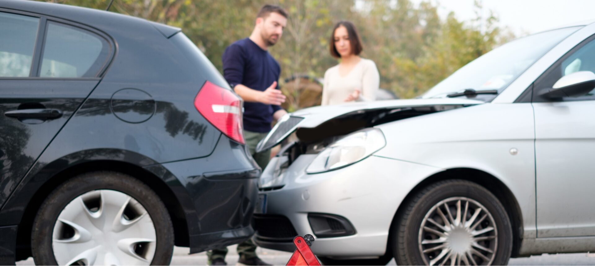 Two cars involved in a car accident with the drivers discussing the scene