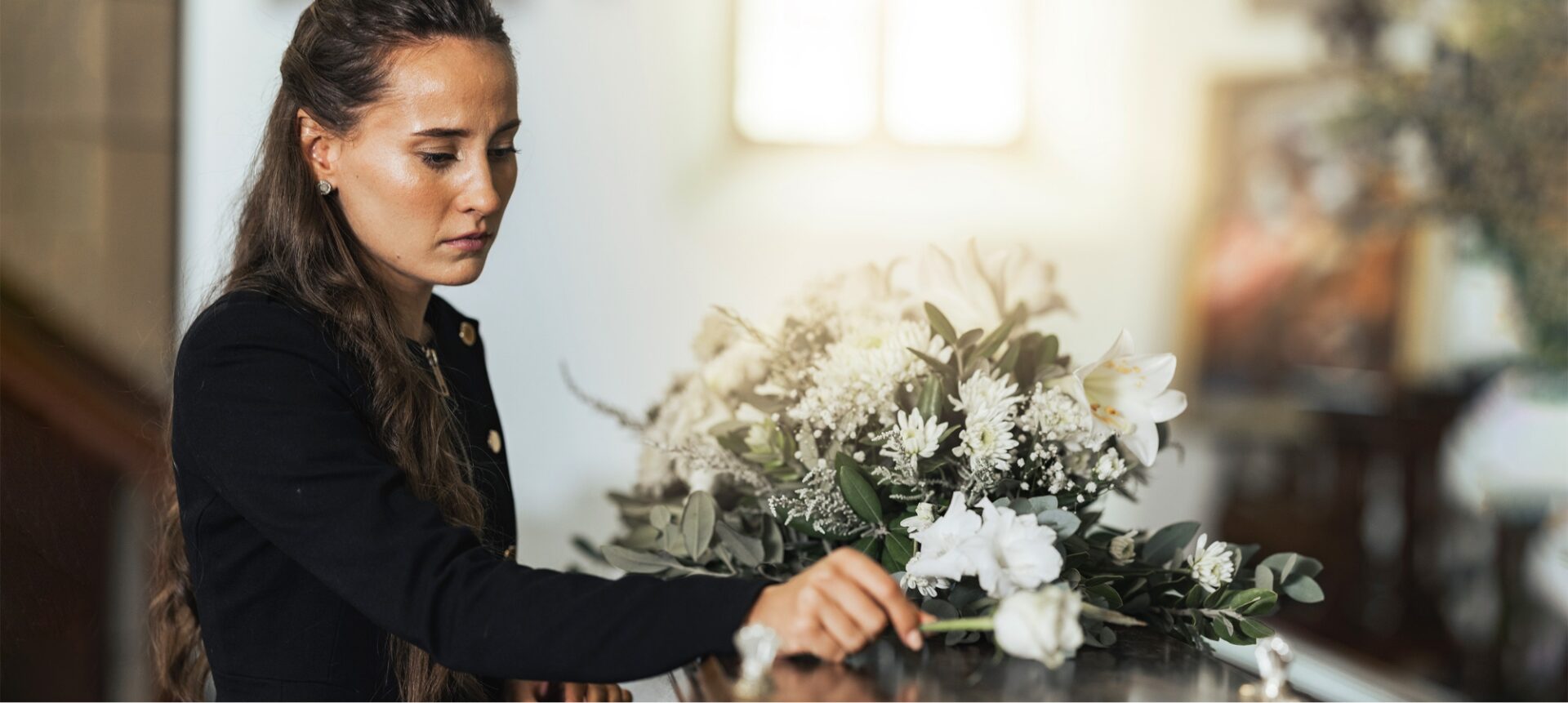A woman placing flowers down at a funeral