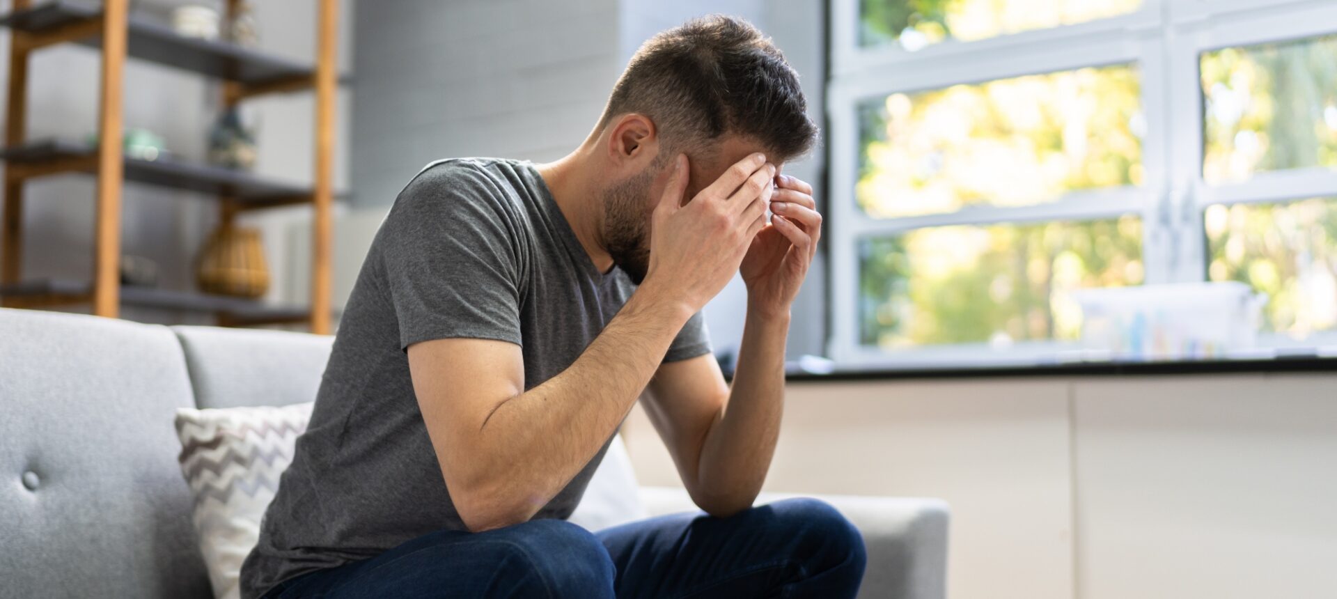 A man holding his head after a TBI.