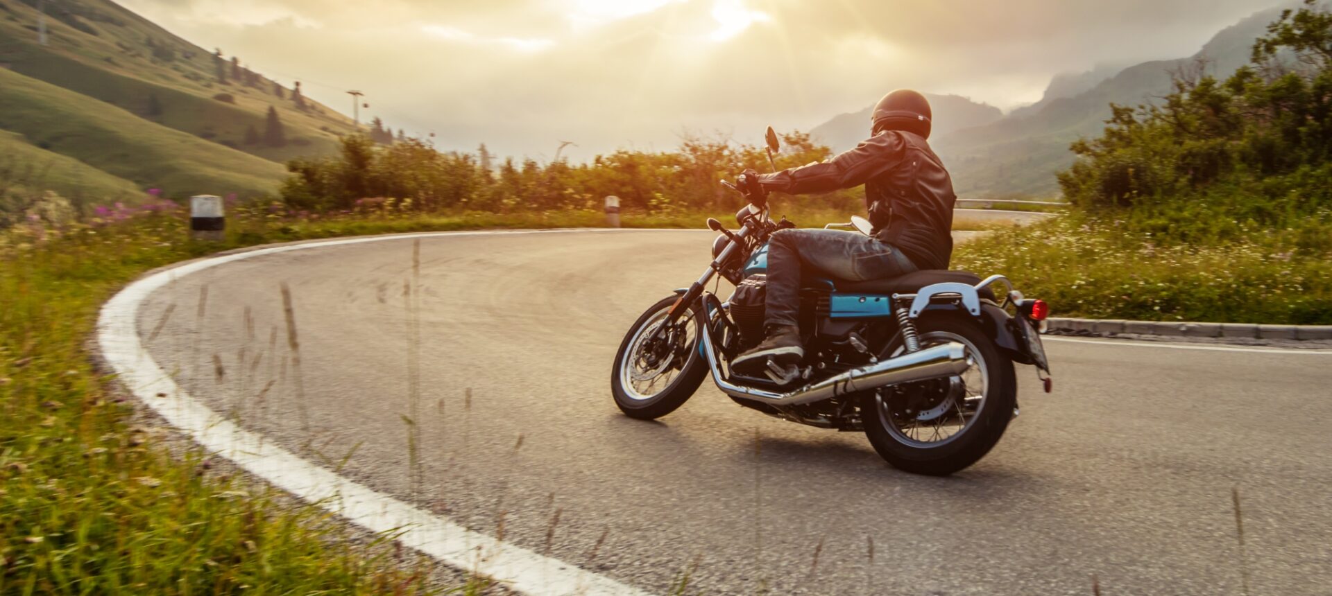 A motorcycle rounding a curve on the roadway